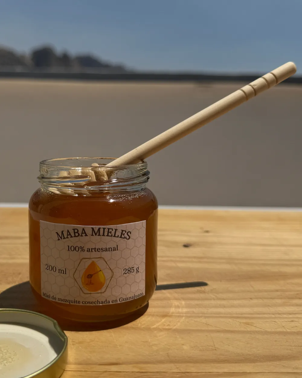 Frasco de miel MABA sobre una mesa de madera